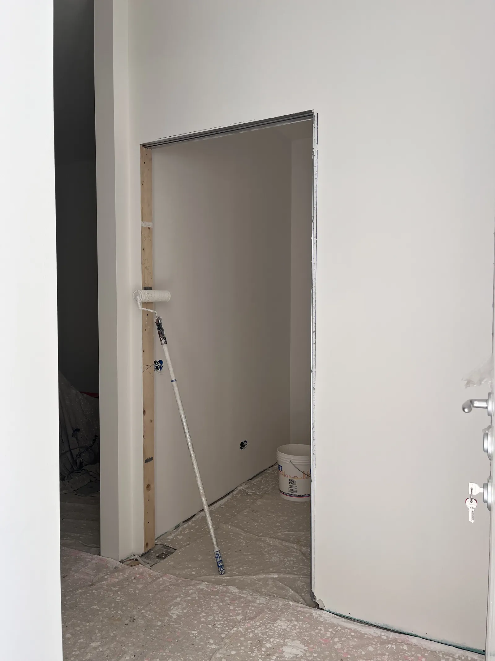 Rullo e telo di protezione durante l'imbiancatura di un soffitto