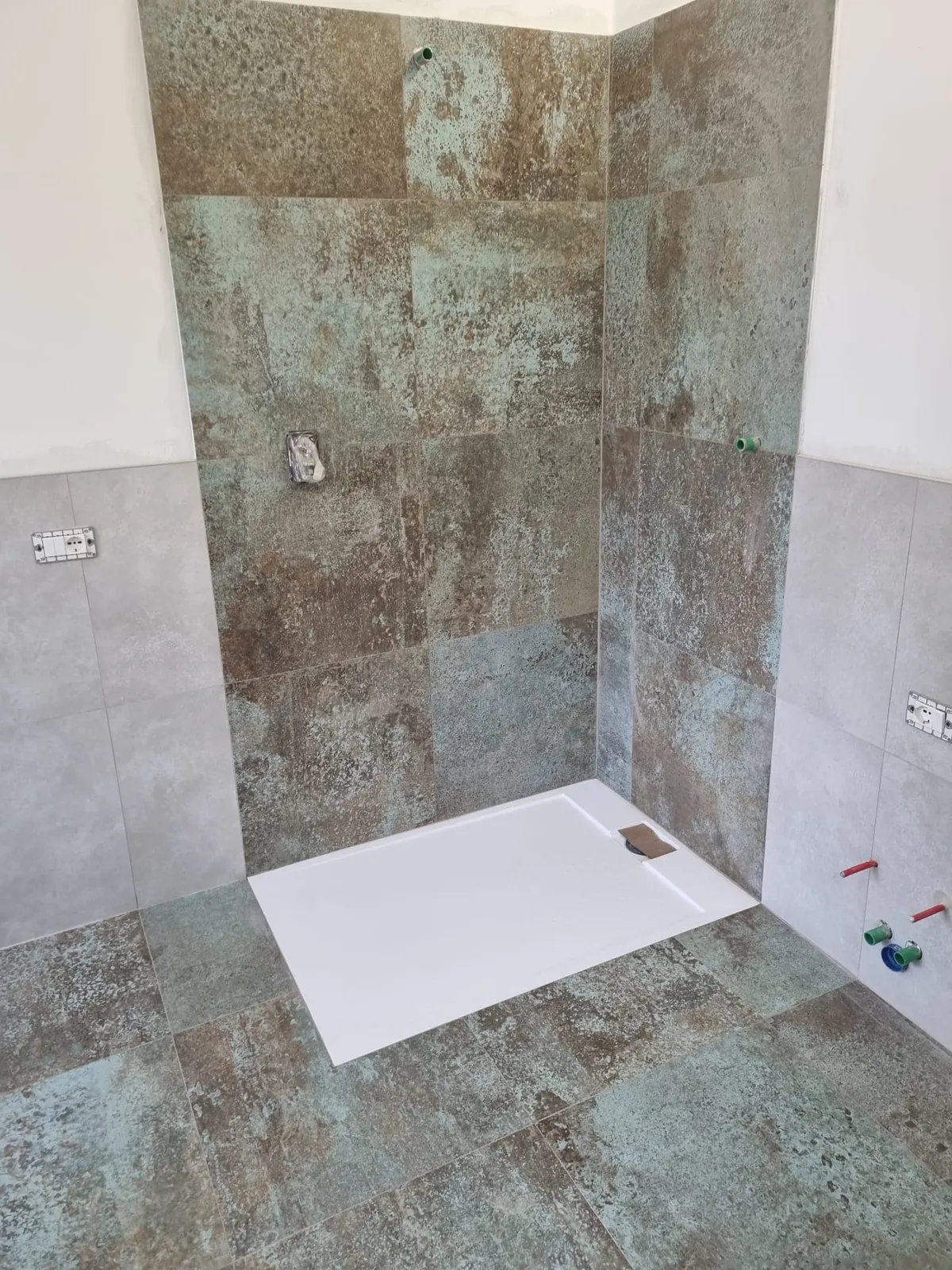 Zona doccia con rivestimento effetto ossido e piatto doccia in appoggio